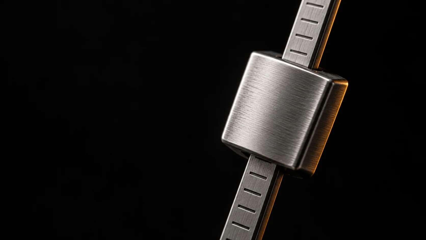 Brushed steel metronome weight held at an off-center angle.