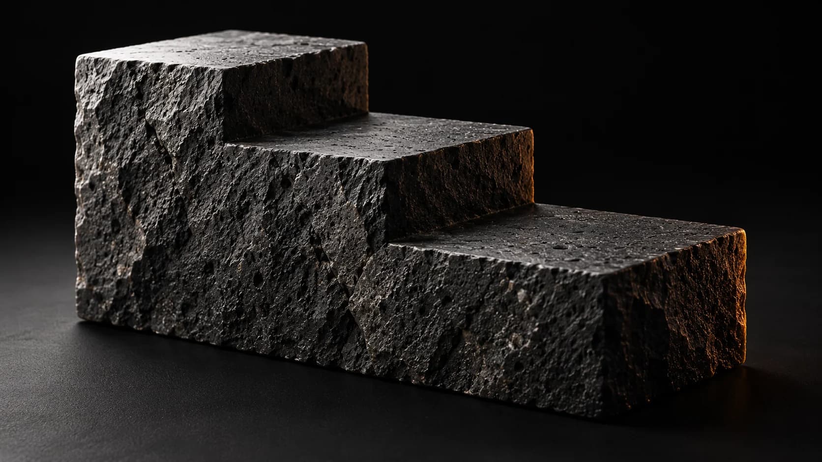 A monolithic black stone block with three steps.
