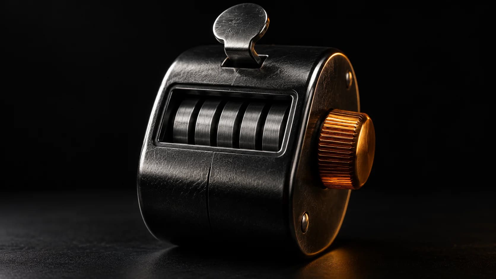 Mechanical tally counter with a single amber-lit reset wheel.