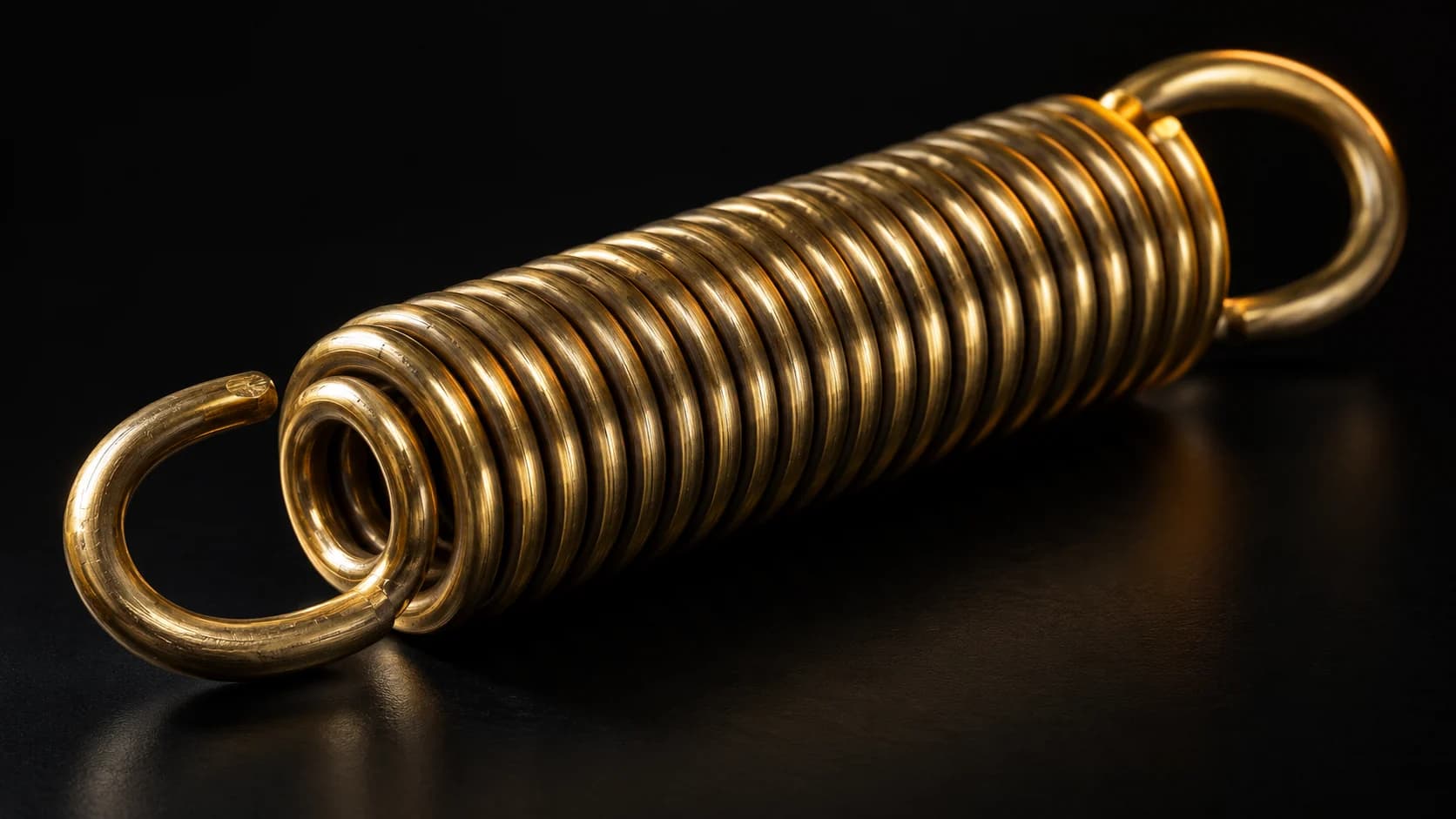 Brass return spring with one compressed amber-lit coil.