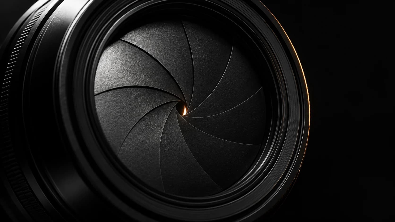Closed black metal aperture with a thin amber opening.
